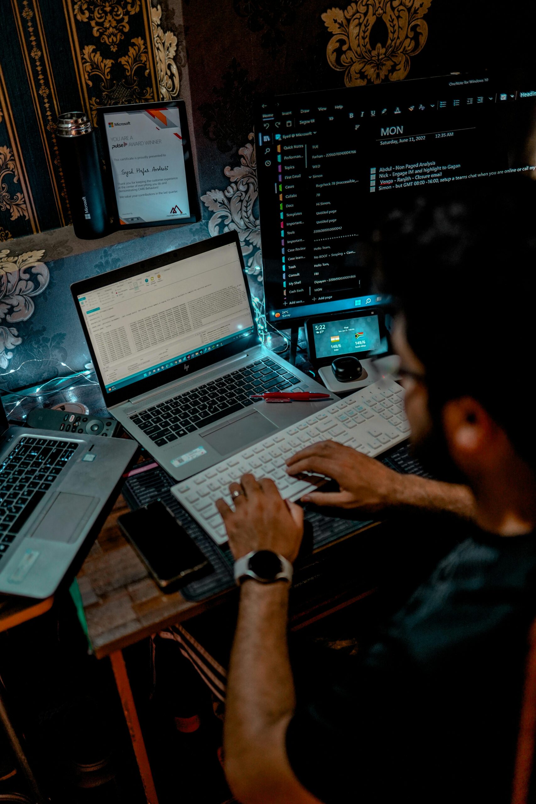 A programmer working with multiple screens in a tech-focused workspace.